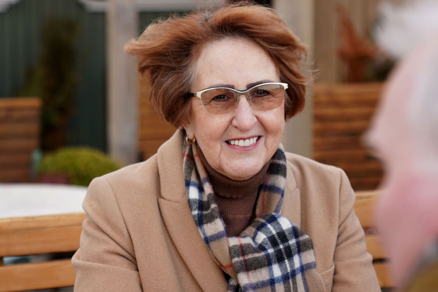 Kona með gleraugu brosir úti