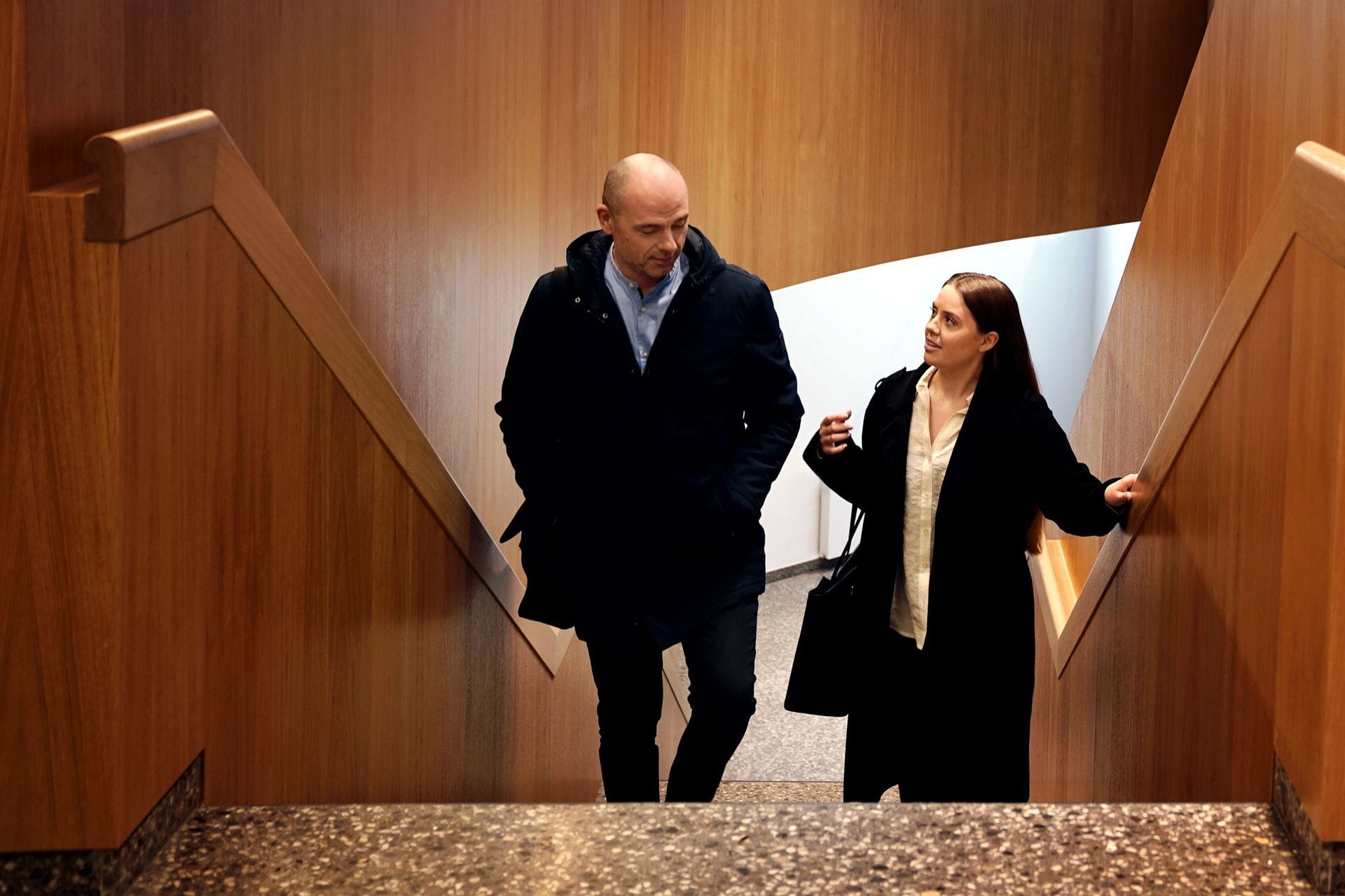 Maður og kona labba hlið við hlið upp stiga