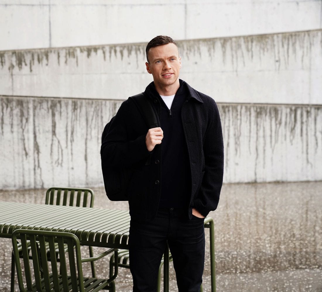 Ungur maður stendur úti með bakpoka